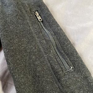 Patagonia sweater color black has a zipper in one of the sleeves